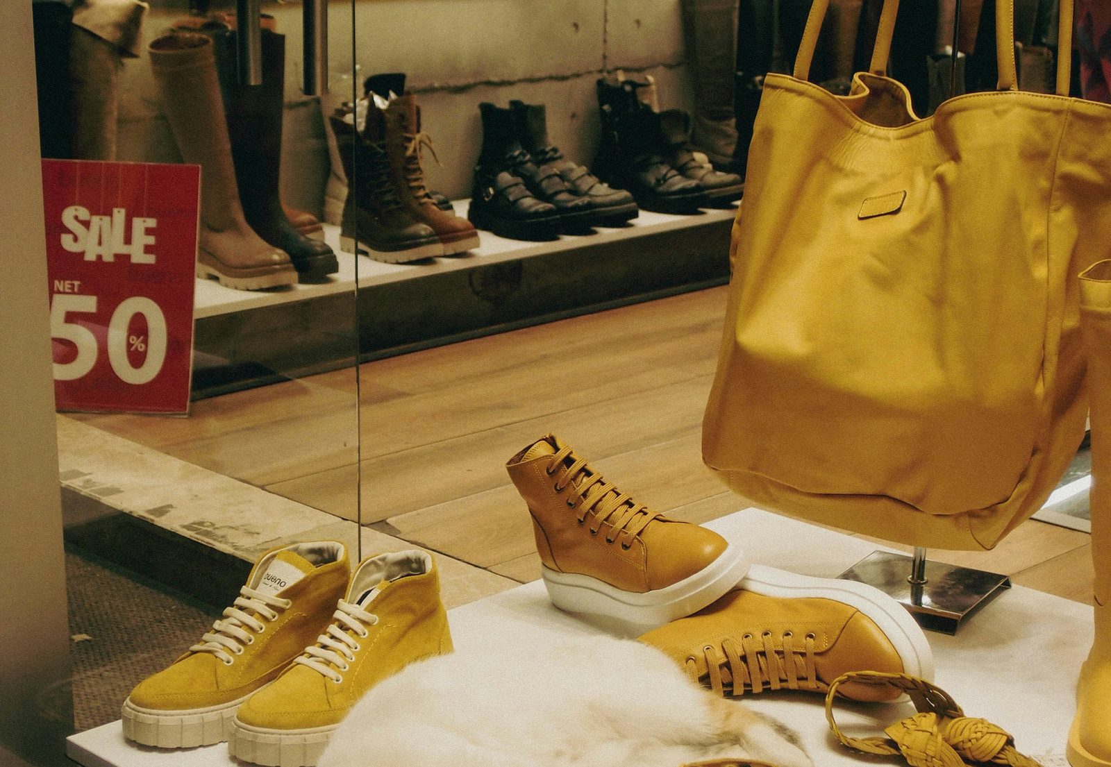 Vetrina calzature con scarpe e cartello di vendita al 50 per cento